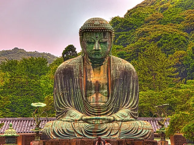 In the middle it is a Buddha statue behind this there are green trees.